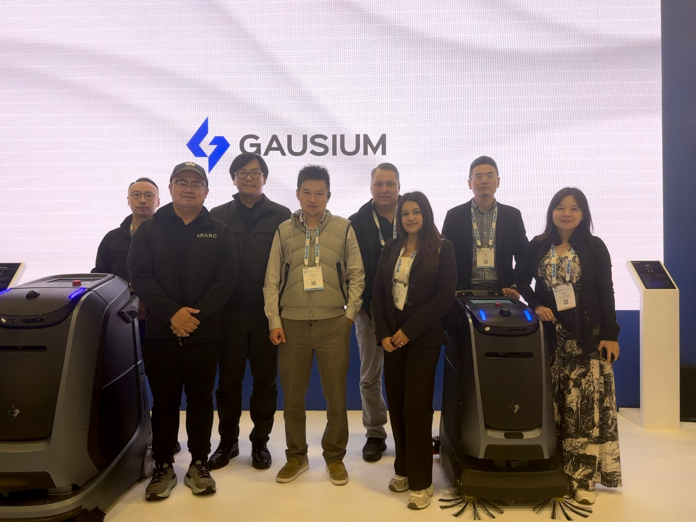 The SPARC team at the Gausium booth with cleaning robots